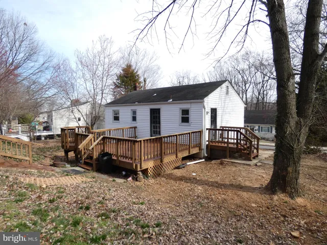 a view of a backyard with couches under an umbrella