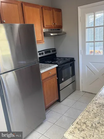 a kitchen with stainless steel appliances granite countertop a refrigerator a sink and a granite counter tops