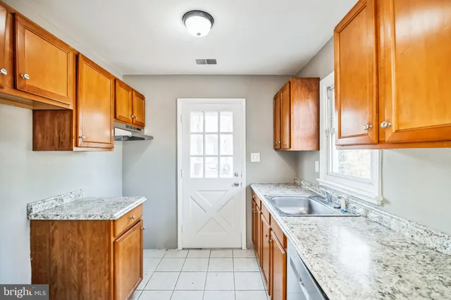 a kitchen that has a sink a window and stainless steel appliances