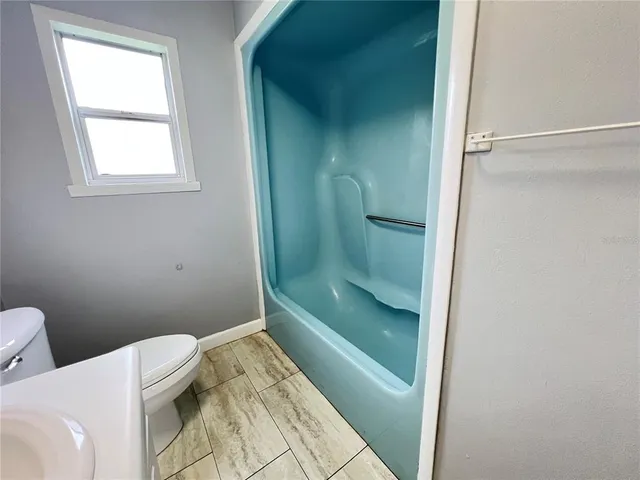 a bathroom with a toilet and a shower