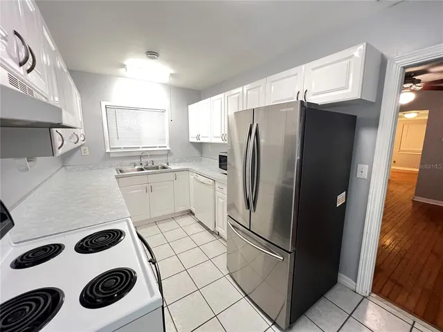 a kitchen with a refrigerator and a stove top oven