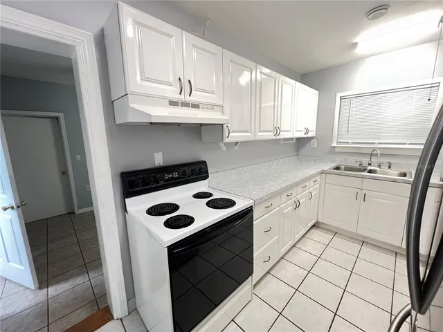 a kitchen with a sink a stove and cabinets