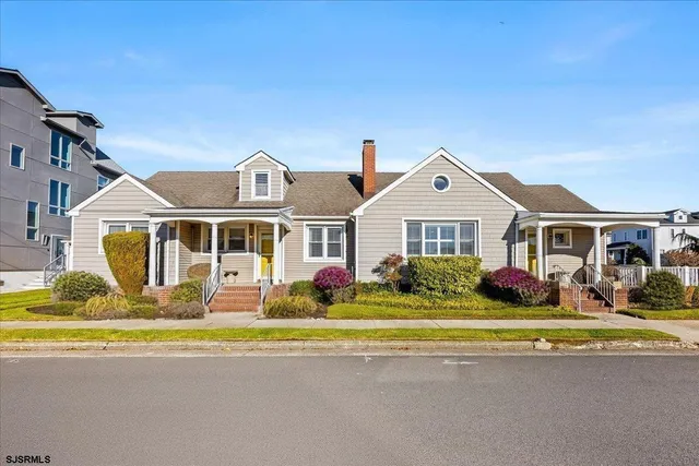a front view of a house with a garden and trees