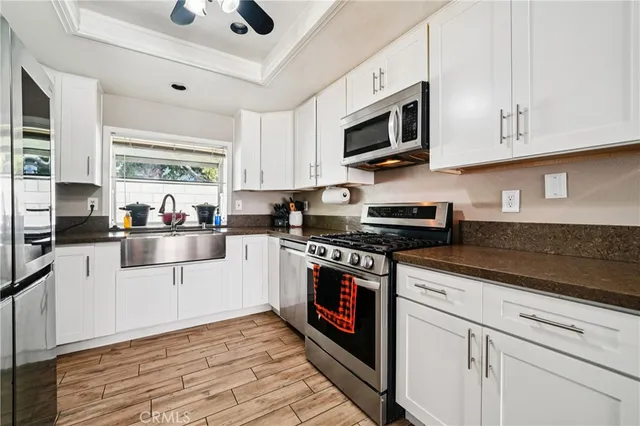 a kitchen with stainless steel appliances granite countertop a stove a sink and a microwave