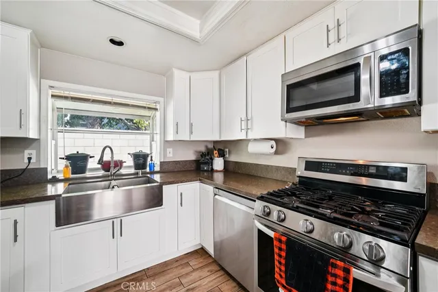 a kitchen with stainless steel appliances a sink a stove and microwave