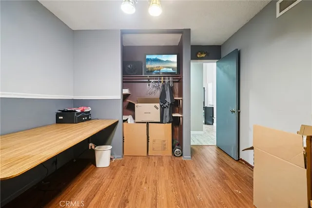 a hallway with a wooden floor and a bathroom