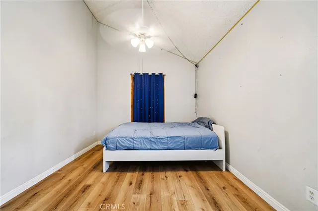 a bedroom with a bed and wooden floor