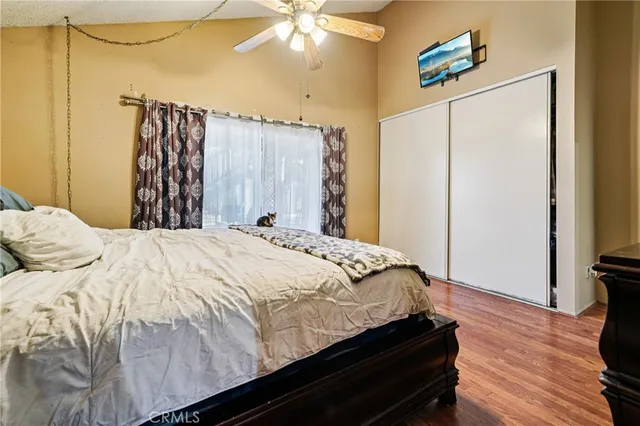a bedroom with a bed and a flat tv screen on a dresser