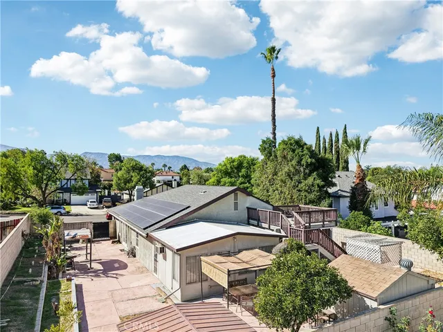 a view of a house with wooden deck and furniture