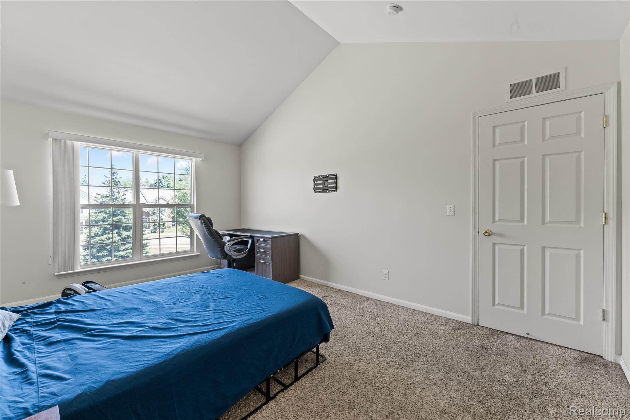 1861 Flagstone Circle Rochester, MI 48307 - Photo 16 of 21 Carpeted room featuring a vaulted ceiling and a large window with vertical blinds