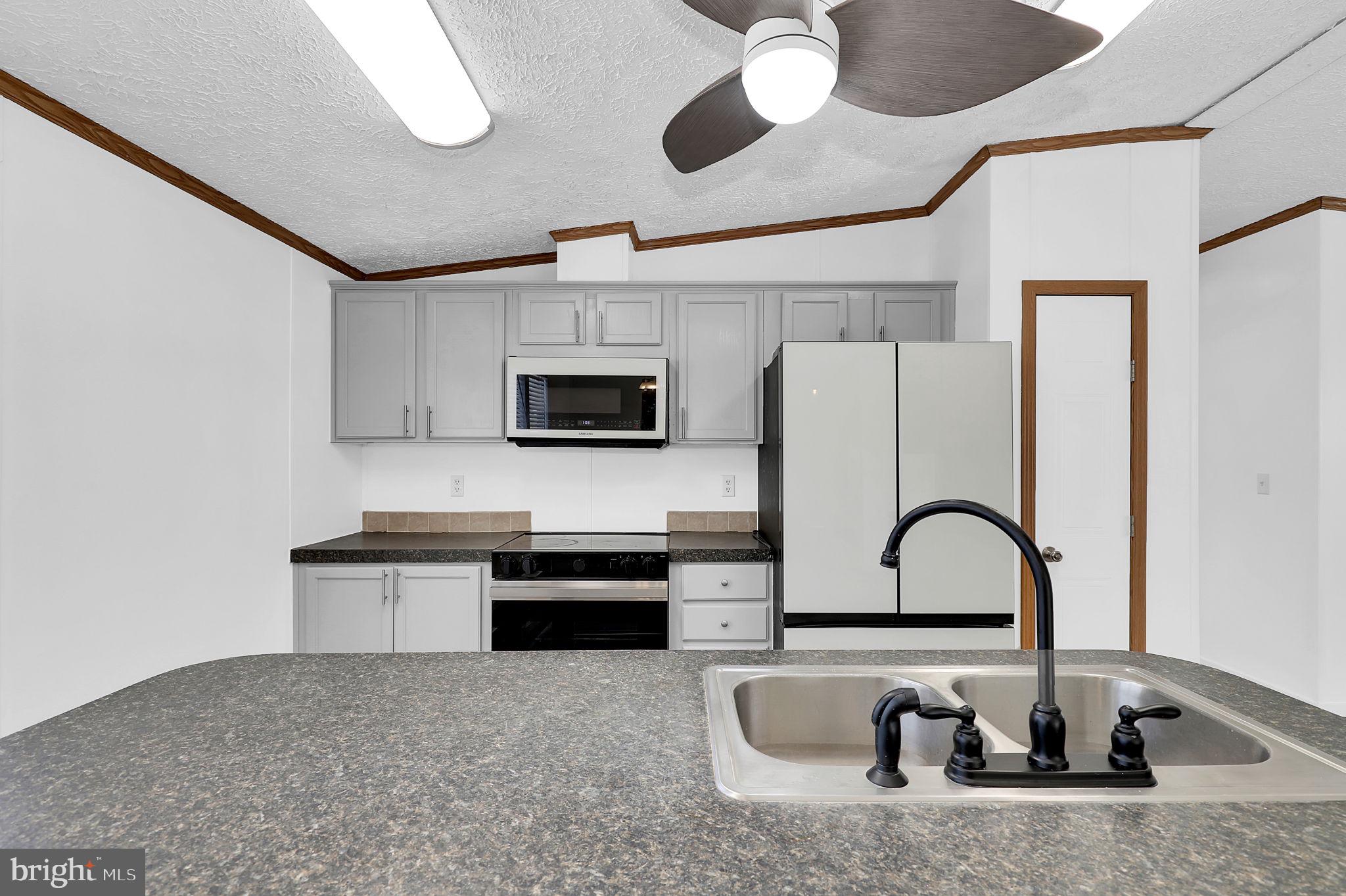 7810 Clark Road, Unit D88 Jessup, MD 20794 - Photo 11 of 30 a kitchen with stainless steel appliances granite countertop a sink a stove and microwave