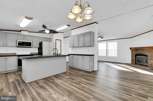 a large kitchen with cabinets wooden floor and stainless steel appliances