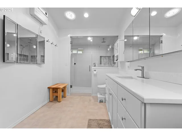 a bathroom with a sink a toilet a mirror and a shower