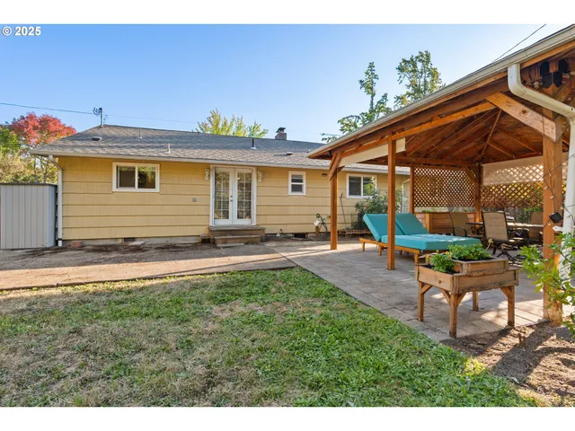 a backyard of a house with table and chairs