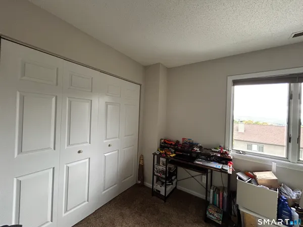 a view of a workspace with furniture and a window
