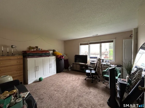 a view of a workspace with furniture and a window