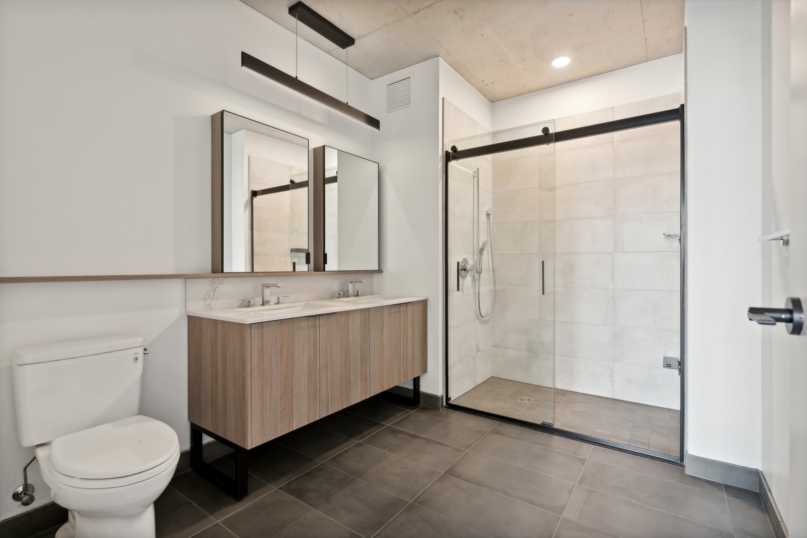234 West Polk Street, Unit 3704 Chicago, IL 60607 - Photo 7 of 30 a bathroom with a double vanity sink toilet and a mirror