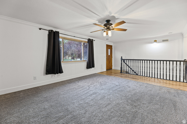 822 Pinewood Circle Price, UT 84501 - Photo 5 of 49 Spacious living area featuring newer gray carpeting, crown molding, and a ceiling fan
