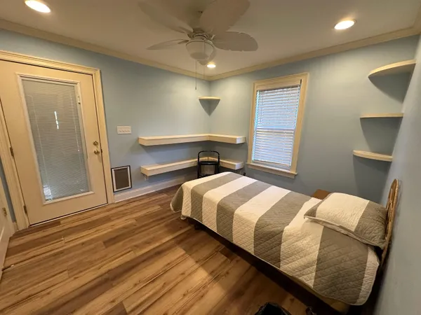 a bedroom with a bed and wooden floor
