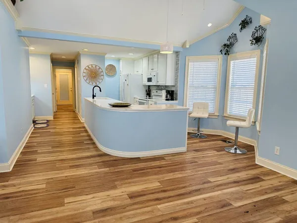 a view of a living room and kitchen with furniture