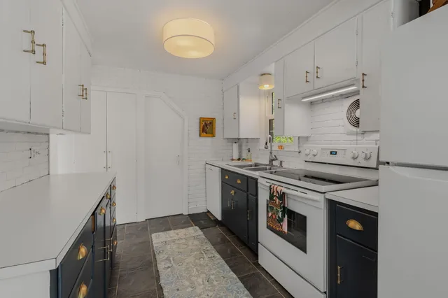 a bathroom with a granite countertop toilet a sink a mirror and a shower