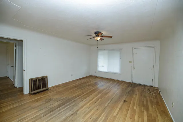 a view of empty room with wooden floor