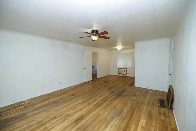 a view of a big room with wooden floor and a ceiling fan