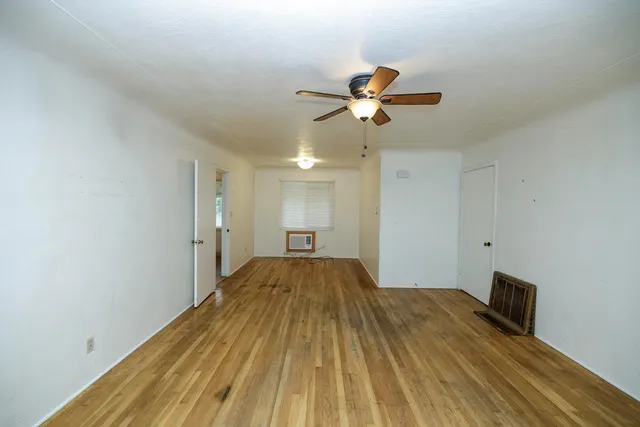 a view of empty room with wooden floor