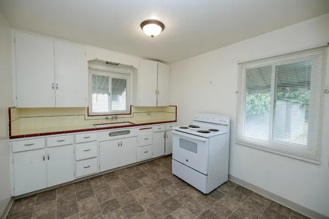 a kitchen with granite countertop white cabinets and white appliances