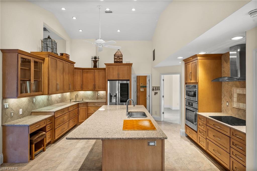 544 Roma Court Naples, FL 34110 - Photo 11 of 41 a large kitchen with stainless steel appliances kitchen island granite countertop a refrigerator and a stove