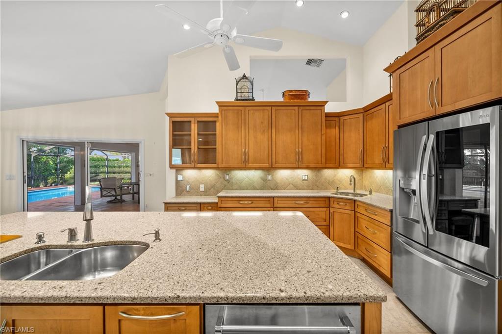 544 Roma Court Naples, FL 34110 - Photo 12 of 41 a kitchen with stainless steel appliances granite countertop a sink and a refrigerator
