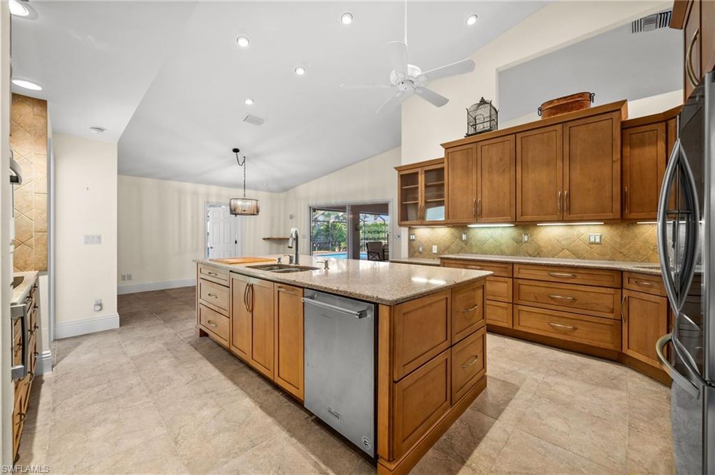 544 Roma Court Naples, FL 34110 - Photo 14 of 41 a kitchen with granite countertop a sink stove and refrigerator