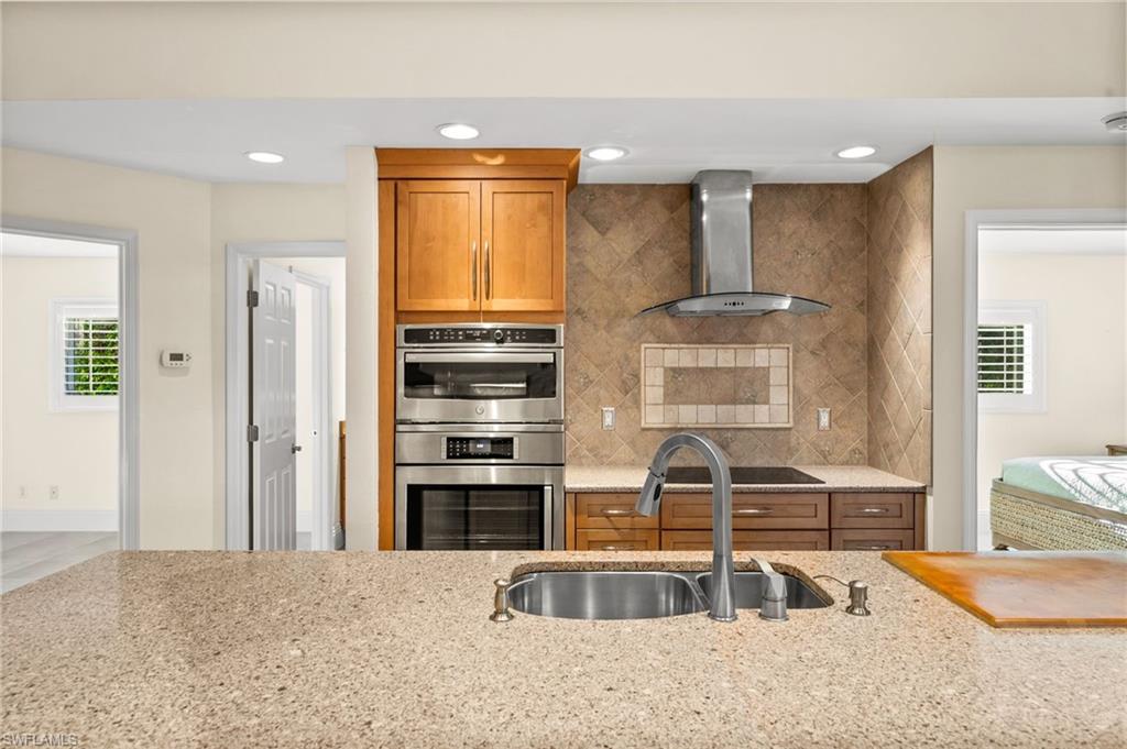544 Roma Court Naples, FL 34110 - Photo 17 of 41 a view of kitchen with stainless steel appliances kitchen island granite countertop a stove and a sink