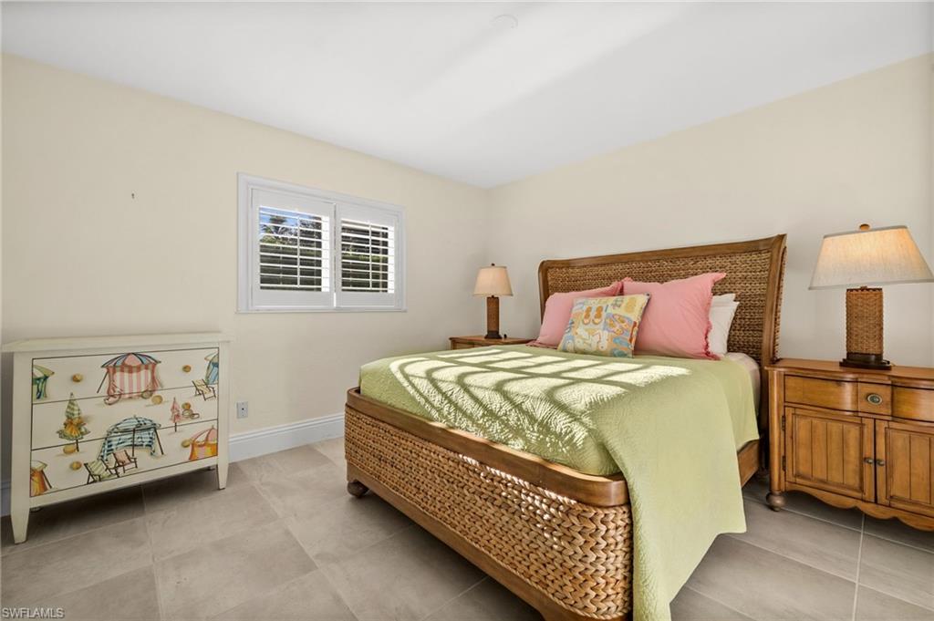544 Roma Court Naples, FL 34110 - Photo 20 of 41 a bedroom with a bed painting on the wall and a baby crib