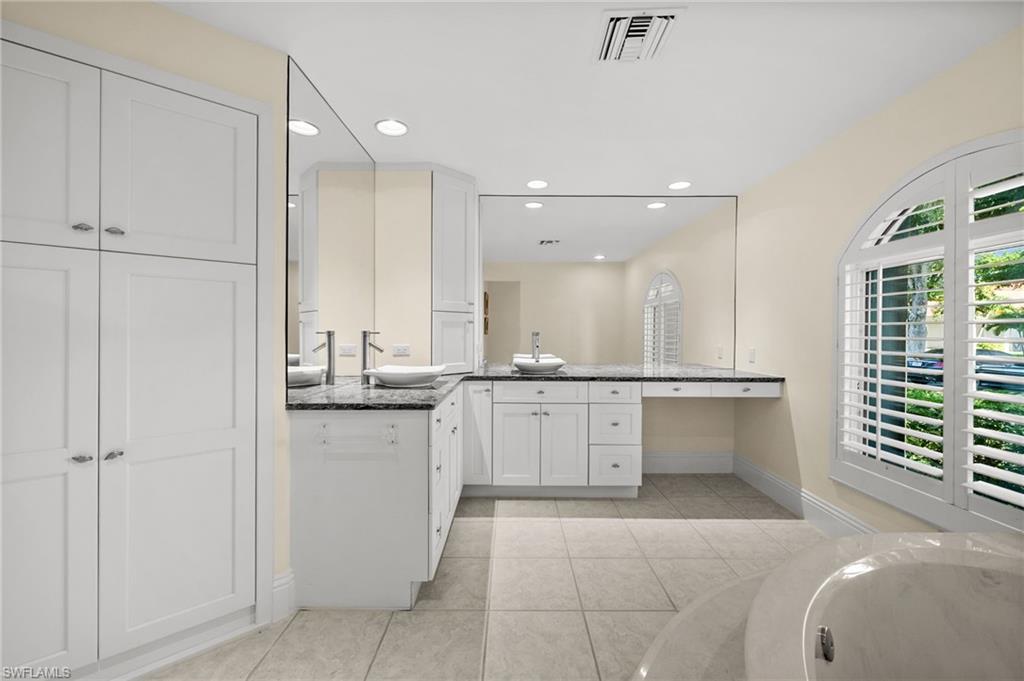 544 Roma Court Naples, FL 34110 - Photo 26 of 41 a large bathroom with a large tub and sink