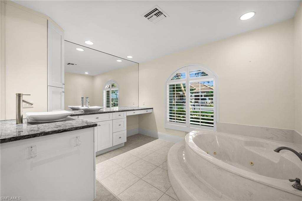 544 Roma Court Naples, FL 34110 - Photo 27 of 41 a spacious bathroom with a granite countertop tub sink and mirror