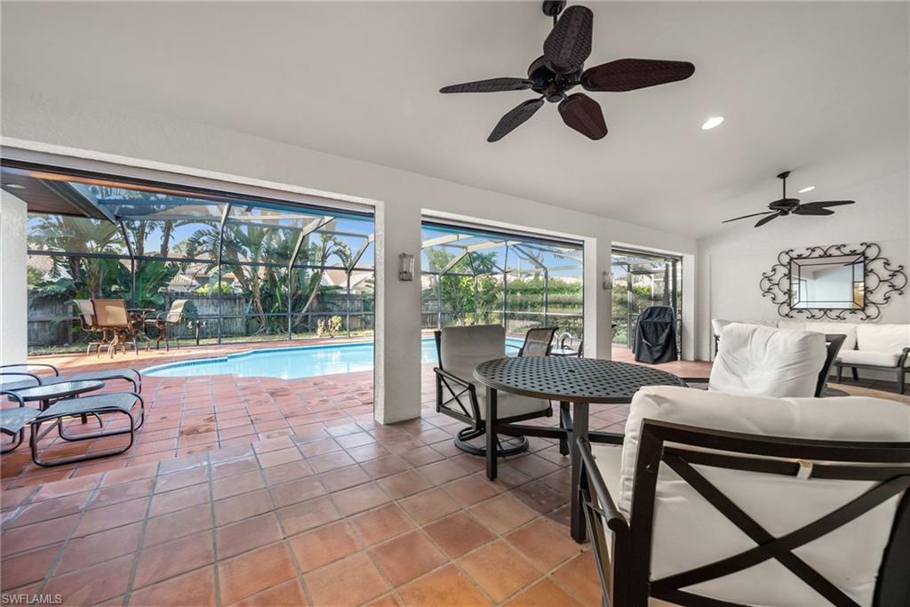 544 Roma Court Naples, FL 34110 - Photo 35 of 41 a living room with furniture and a floor to ceiling window