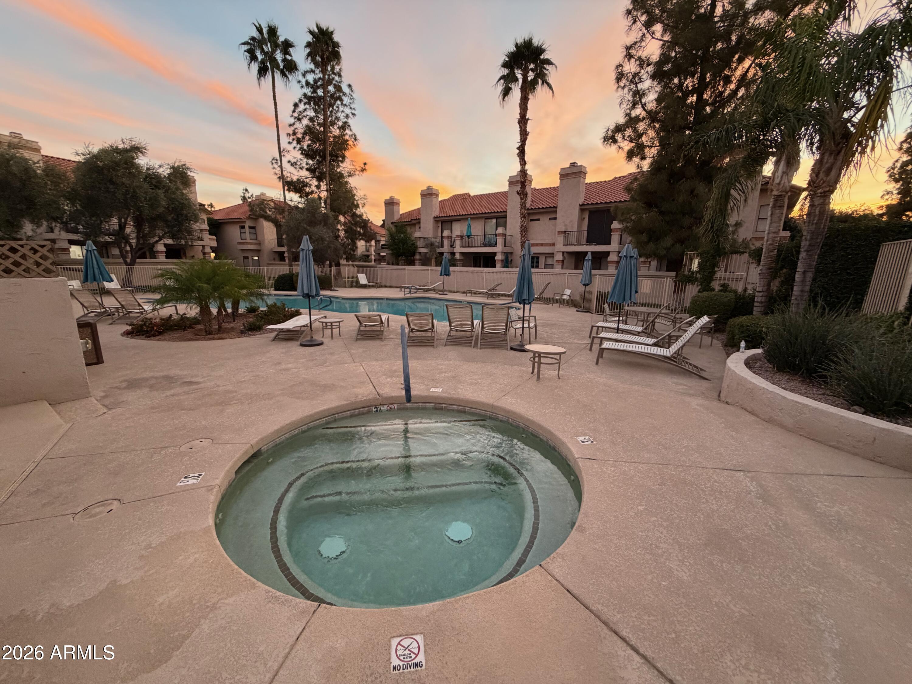 9705 East Mountain View Road, Unit 1126 Scottsdale, AZ 85258 - Photo 27 of 33 a view of a swimming pool with a patio and dining table