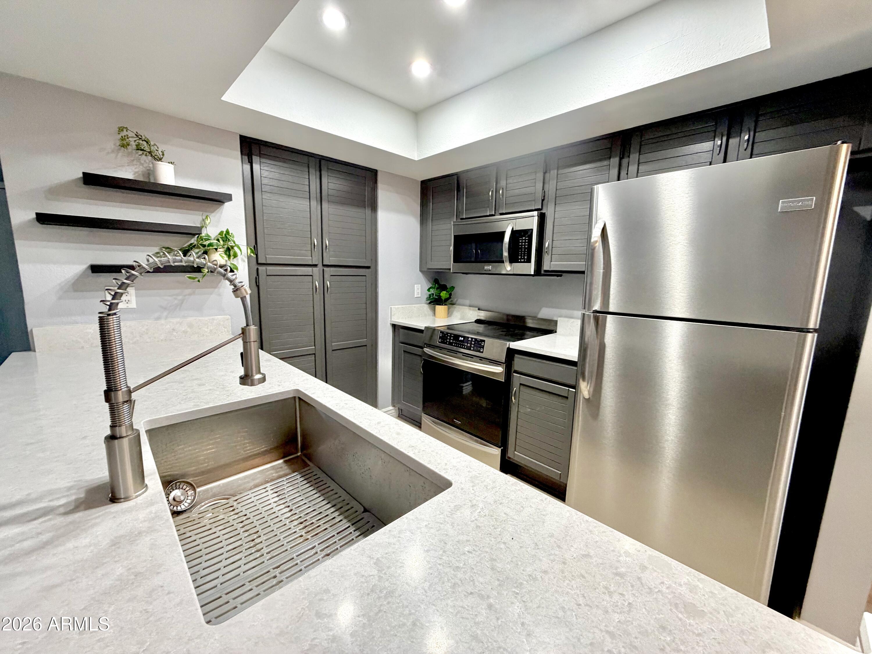 9705 East Mountain View Road, Unit 1126 Scottsdale, AZ 85258 - Photo 6 of 33 a kitchen with a refrigerator and a sink