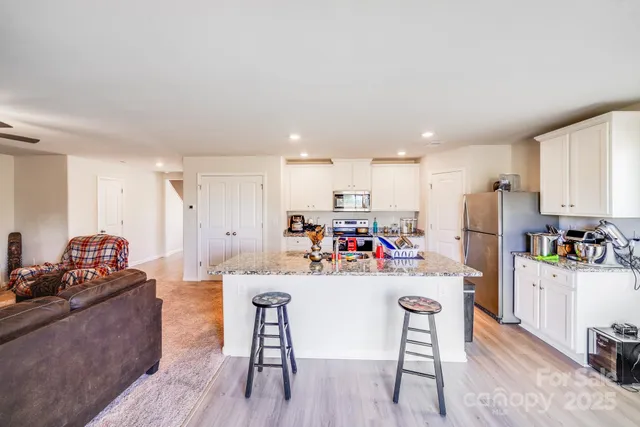a kitchen with stainless steel appliances kitchen island wooden cabinets and refrigerator
