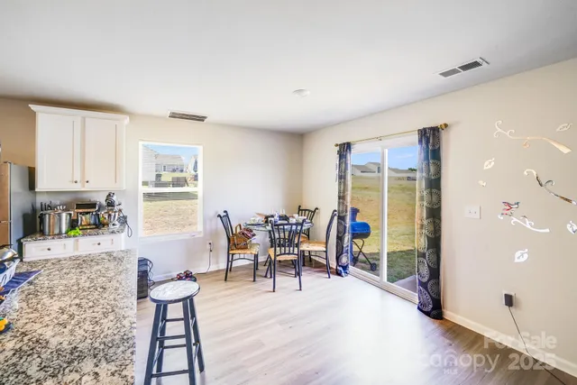 a dining room with furniture and wooden floor