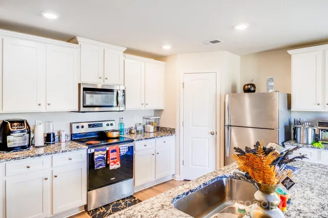a kitchen with stainless steel appliances granite countertop a refrigerator sink and cabinets