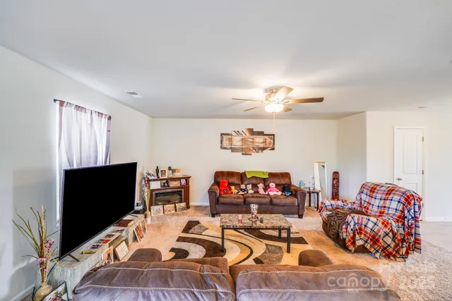 a living room with furniture a flat screen tv and a window