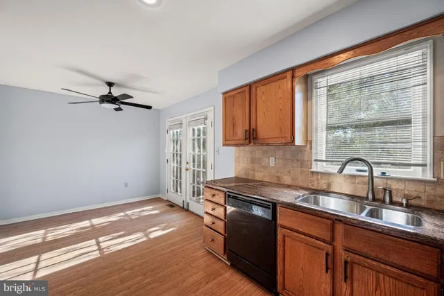 a kitchen with granite countertop a sink stainless steel appliances and cabinets