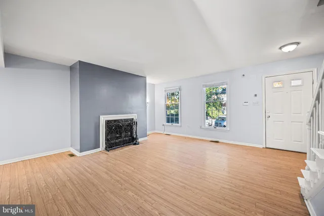 an empty room with windows and fireplace