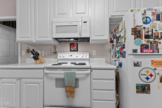 a kitchen with stainless steel appliances granite countertop a white stove top oven and a sink