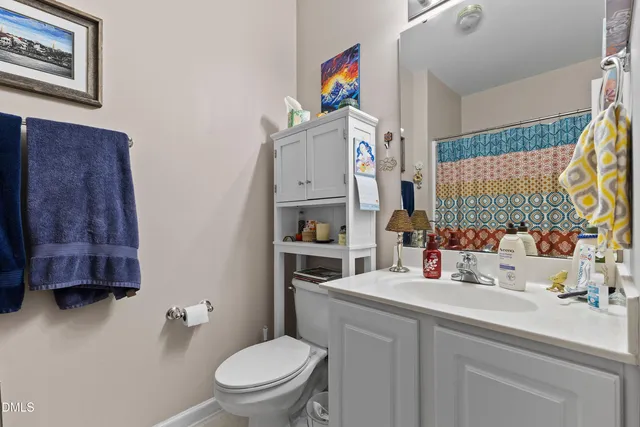 a bathroom with a sink vanity mirror and toilet