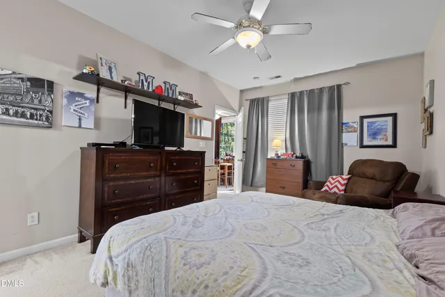 a bedroom with a bed dresser and a flat screen tv