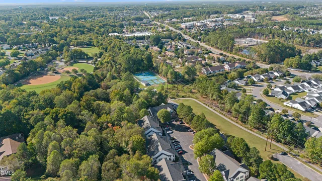 an aerial view of residential houses with outdoor space and trees