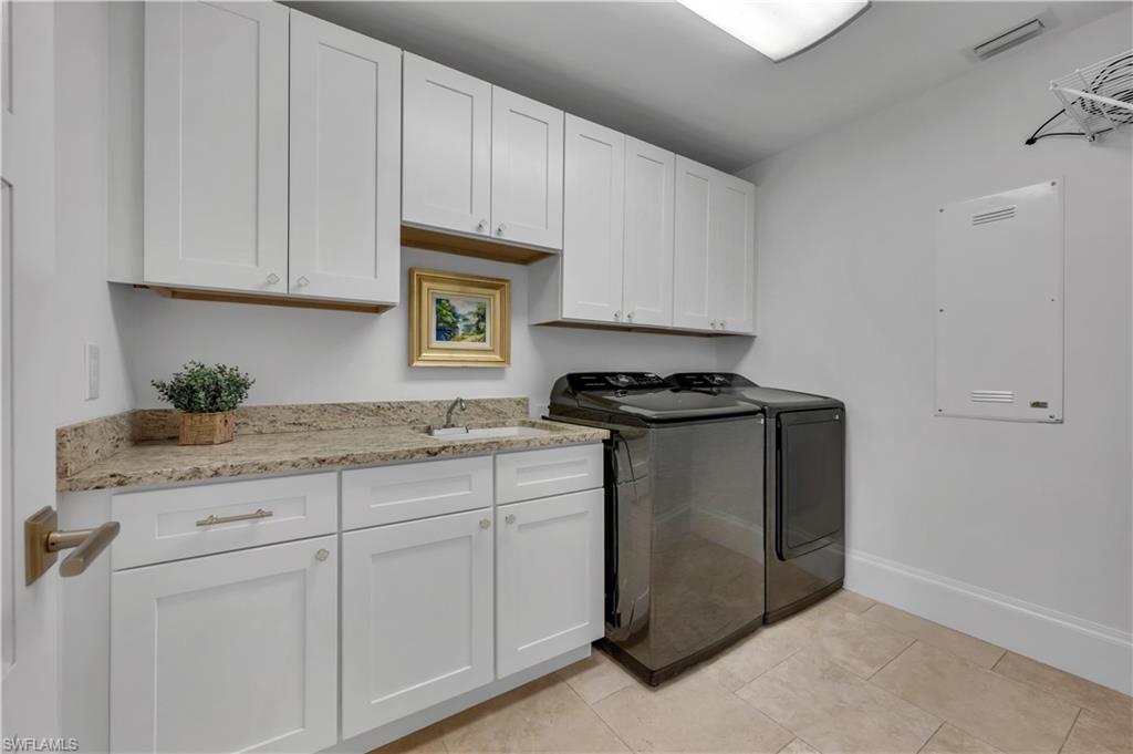 718 Old Trail Drive Naples, FL 34103 - Photo 13 of 18 Laundry area with cabinet space, washing machine and dryer, and light tile patterned floors